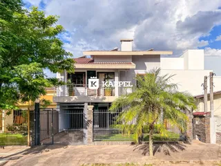 Fachada de uma residência em Lajeado, Brasil, com jardim e portão de segurança.