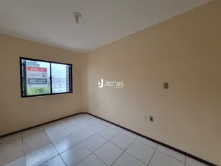 Sala de estar com piso de cerâmica clara e parede bege.