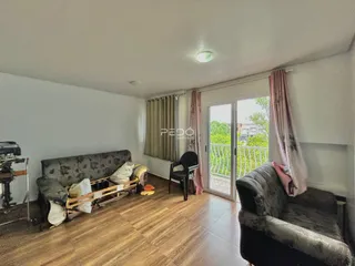 Sala de estar com piso de madeira e móveis.
