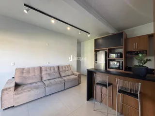 Sala de estar com sofá e móveis de madeira em um imóvel no Brasil.