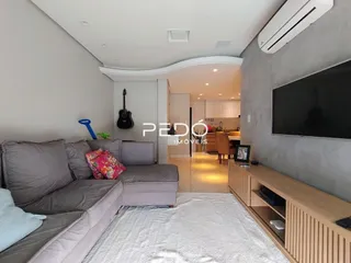Sala de estar moderna com sofá e televisão em um apartamento.
