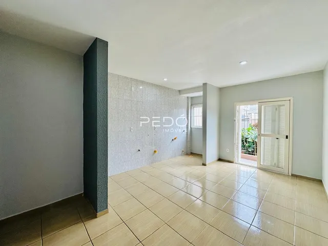 A sala de estar apresenta piso de cerâmica claro e paredes brancas.