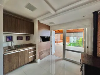 Vista interna de uma cozinha com armários de madeira e acesso a uma área externa.