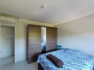 Quarto com armário de madeira e cama.