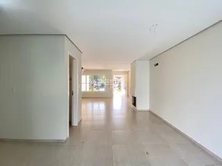 Vista do corredor interno de uma residência com piso de cerâmica clara.