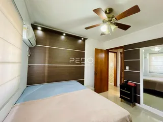 Quarto com cama e parede de destaque em madeira escura.