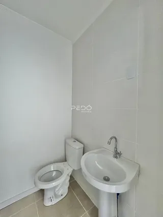Foto de um banheiro com azulejos brancos.