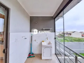 Foto de um interior com paredes brancas e uma máquina de lavar roupa.