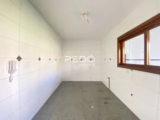Vista interna de um corredor com paredes brancas e piso de concreto.