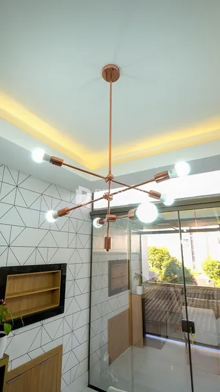Ambiente interno com teto moderno e porta de vidro que dá acesso a uma área externa.