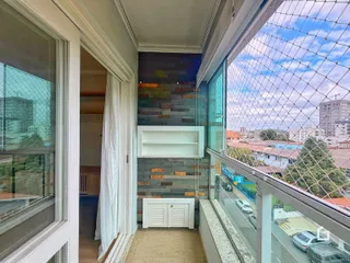 Vista interna de um ambiente com parede de pedra e acesso à varanda.