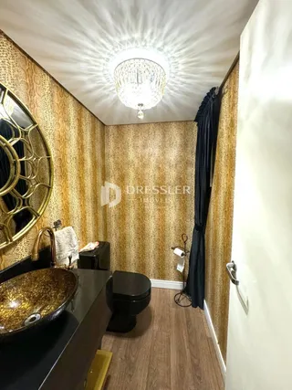 Foto de um banheiro com revestimento dourado e piso de madeira.