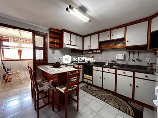 Uma cozinha com armários de madeira e bancada é visível na propriedade.