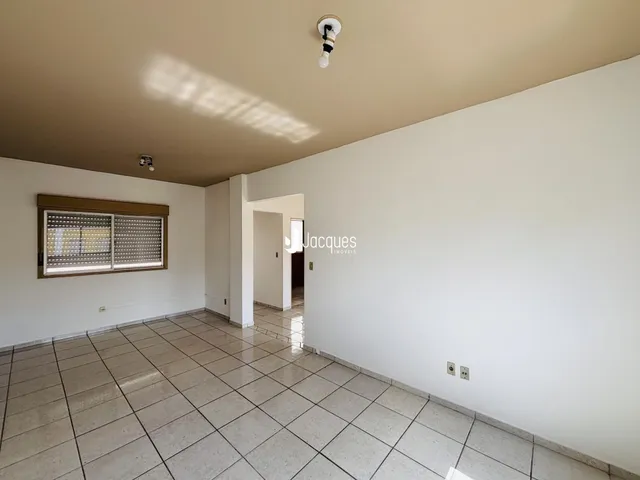 Interior de uma sala com piso de cerâmica e parede branca.