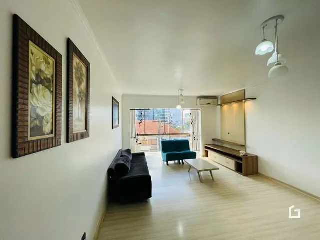 Sala de estar com piso de madeira clara e paredes brancas.