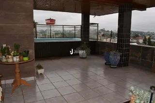 Vista de um terraço com piscina e grade de segurança em uma propriedade.