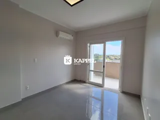 Sala de estar clara com piso de porcelanato e porta de vidro com vista para o exterior.