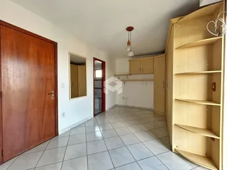 Interior de uma sala com piso de cerâmica e armário em madeira.