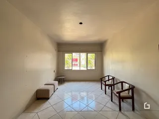 Corredor com piso de cerâmica e janela no final.