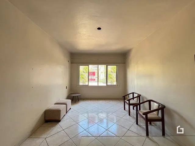 Corredor com piso de cerâmica e janela no final.