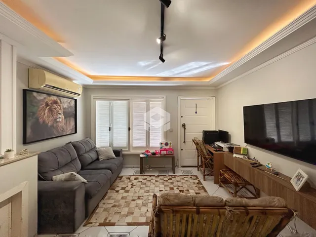 Sala de estar com sofá e televisão em um imóvel.