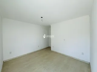 Foto de um ambiente interno com paredes brancas e piso de madeira clara.