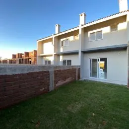 Fachada de uma residência com parede de tijolos vermelhos e gramado em Lajeado, Brasil.