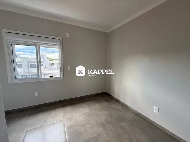 Ambiente interno com paredes cinzas e piso de cerâmica, mostrando uma janela.