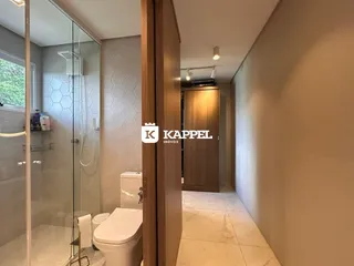 Um banheiro com box de vidro e vaso sanitário branco é visível na área interna da propriedade.
