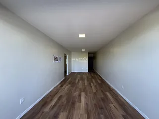 Corredor interno de um imóvel em Lajeado, Brasil, com piso de madeira.