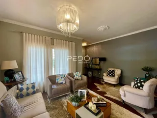 Sala de estar com decoração elegante e cortinas brancas.