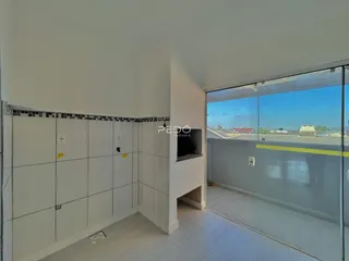 Interior de um ambiente com piso de madeira e parede branca.