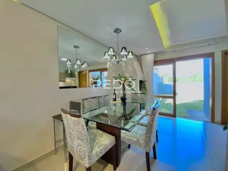 Sala de estar com mesa de vidro e cadeiras em um imóvel no Brasil.