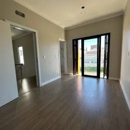 Ambiente interno com piso de madeira e teto de gesso.
