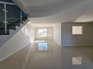 Vista de um corredor interno bem iluminado com escadaria.