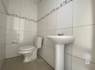 Foto de um banheiro com azulejos brancos.