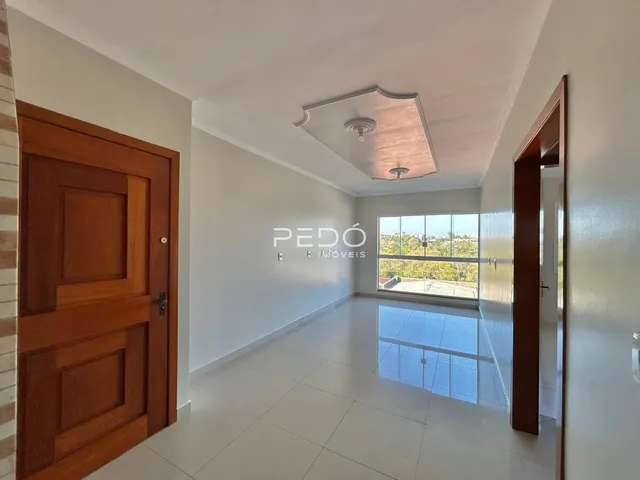 Hall de entrada com piso claro e portas de madeira em um imóvel no Brasil.