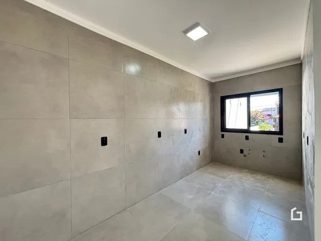 Parede interna com revestimento de cerâmica cinza claro em um imóvel.