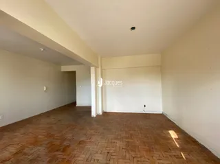 Interior de uma sala com piso de cerâmica e paredes brancas.