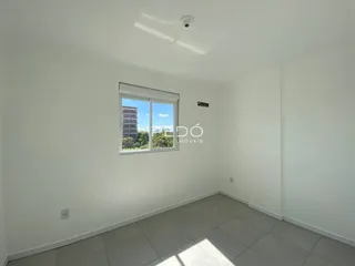 Ambiente interno de uma sala com piso de cerâmica e grande janela.