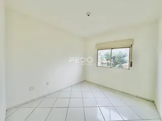 Interior de um ambiente com piso de cerâmica branca e paredes brancas.