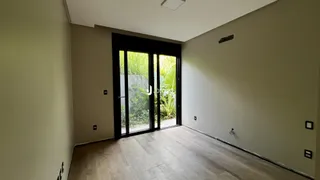 Vista interna de uma sala com porta de vidro que se abre para o exterior.