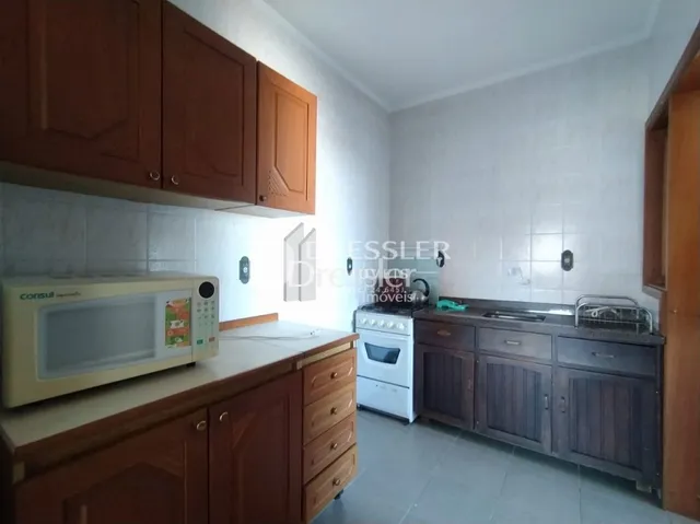Foto de uma cozinha com armários de madeira e piso cerâmico.