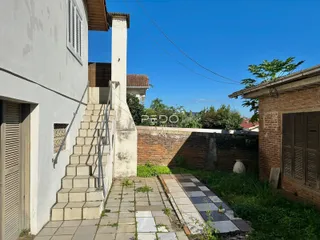 Vista da fachada de uma residência com escadaria e muro de tijolos em Lajeado.