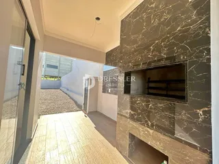 Vista de um corredor interno com parede revestida em mármore escuro e piso de cerâmica.