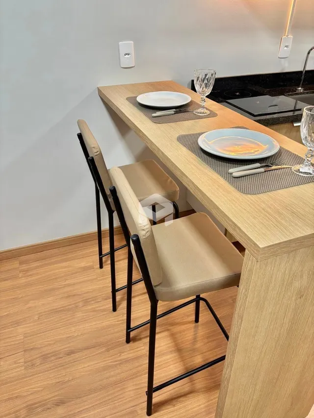 Vista de uma mesa de jantar de madeira com cadeiras em um ambiente interno.