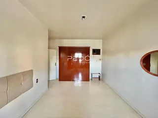 Hall de entrada com paredes brancas e piso claro.