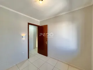 Hall de entrada com piso de cerâmica e porta de madeira.