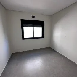 Ambiente interno com piso cinza e paredes brancas.