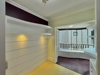 Interior de uma sala com paredes brancas e detalhes em painéis na Lajeado.